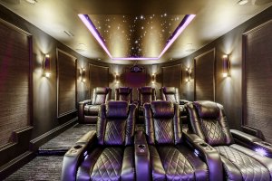 Luxurious home theater basement renovation in Toronto with leather recliners, starlight ceiling, and ambient wall sconces for a cinematic experience."