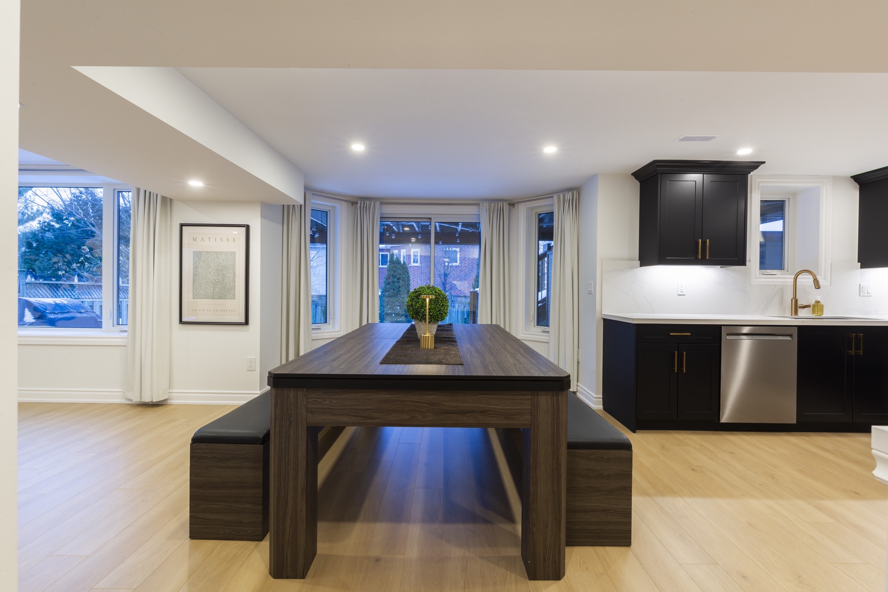 The dining table and bench seating sit beside the kitchen, within the same connected space.