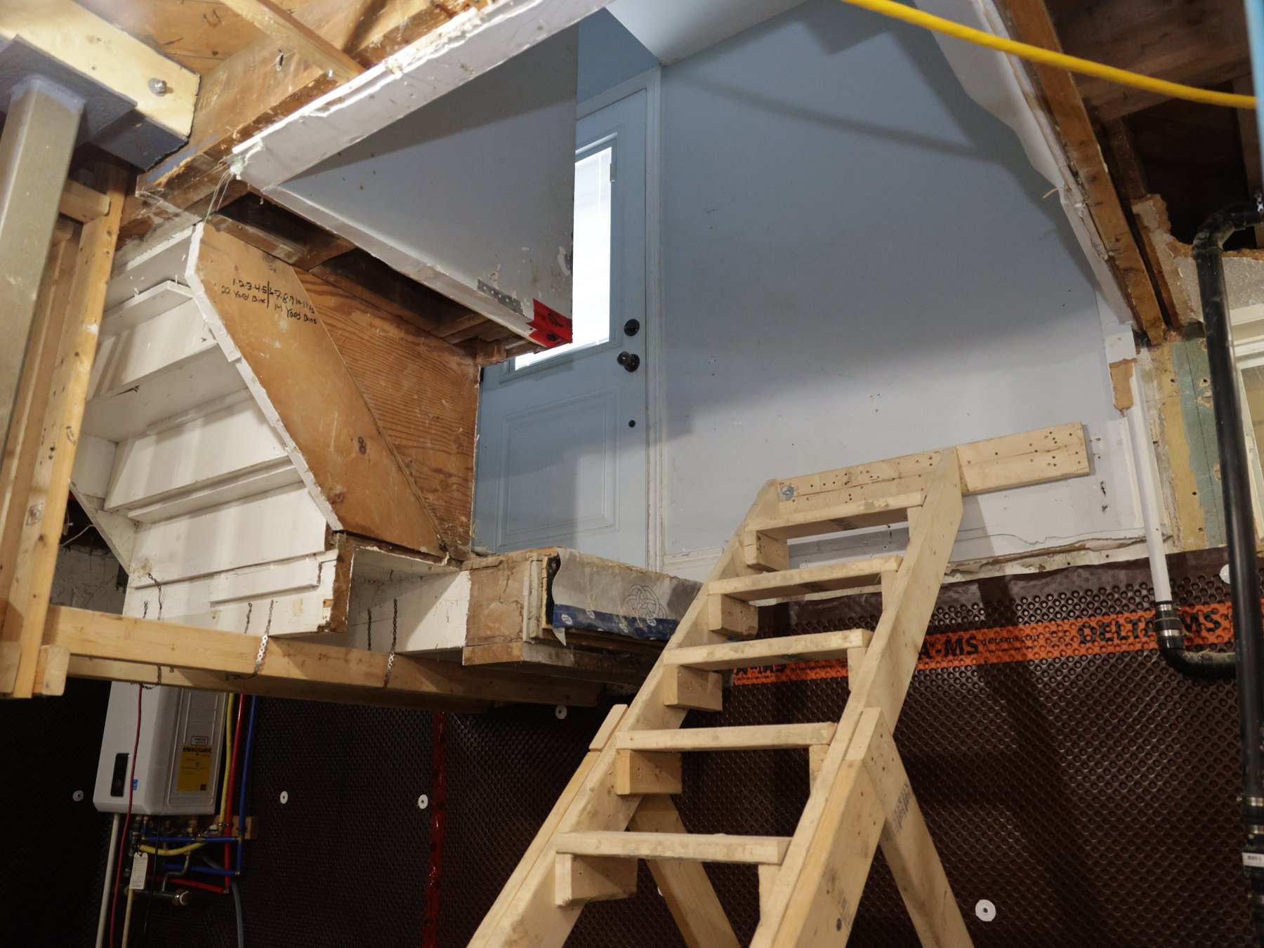 Temporary timber stair beneath a doorway in a Scarborough basement during construction